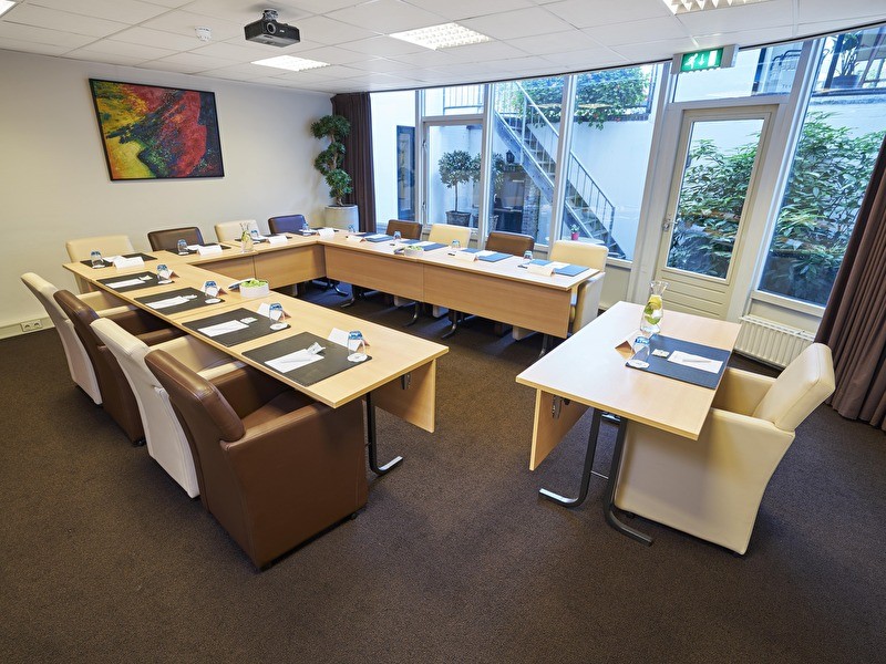 A spacious, bright room with a central table, ideal for meetings or gatherings.